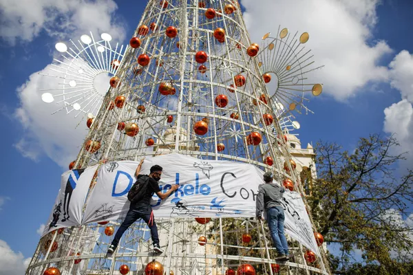 Varios activistas cuelgan una pancarta en un árbol de Navidad en San Salvador durante una protesta contra las políticas del presidente Nayib Bukele. Varios activistas cuelgan una pancarta en un árbol de Navidad en San Salvador durante una protesta contra las políticas del presidente Nayib Bukele. - Sputnik Mundo