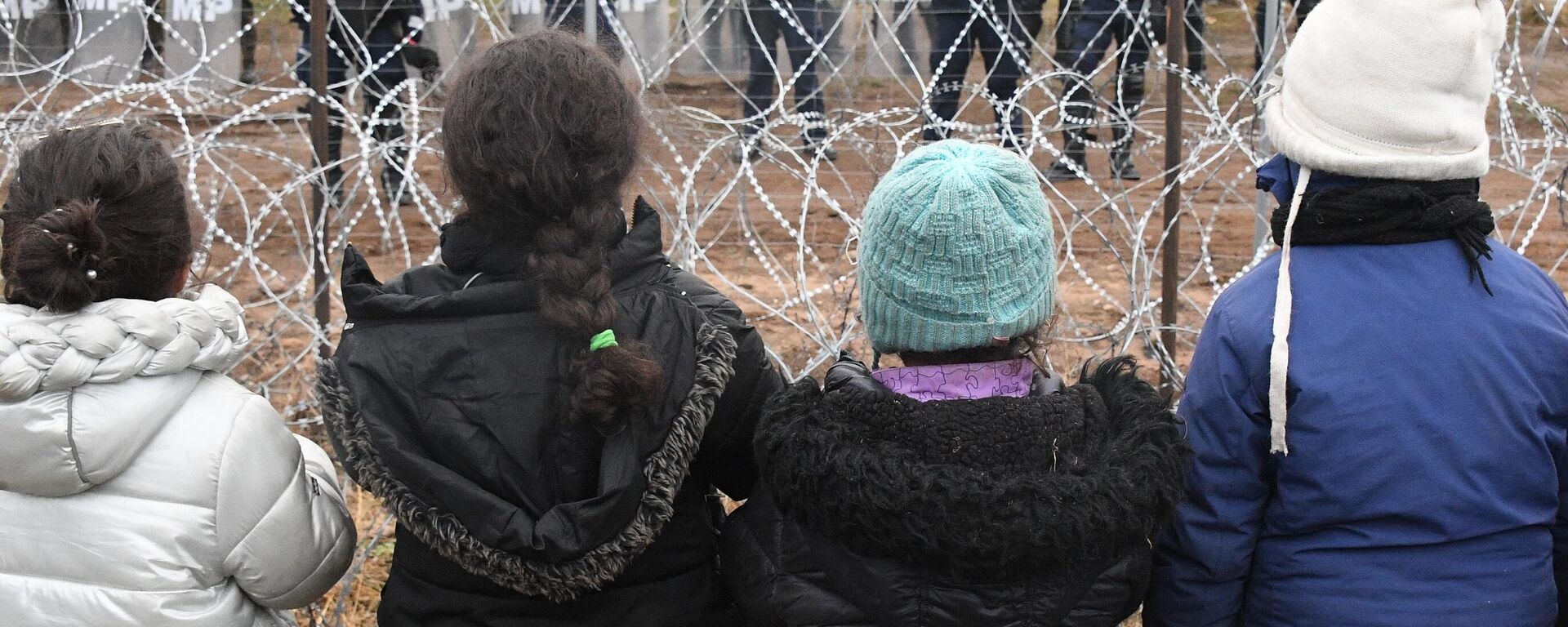 Niñas migrantes en la frontera de Bielorrusia con Polonia Niñas migrantes en la frontera de Bielorrusia con Polonia - Sputnik Mundo, 1920, 14.01.2022