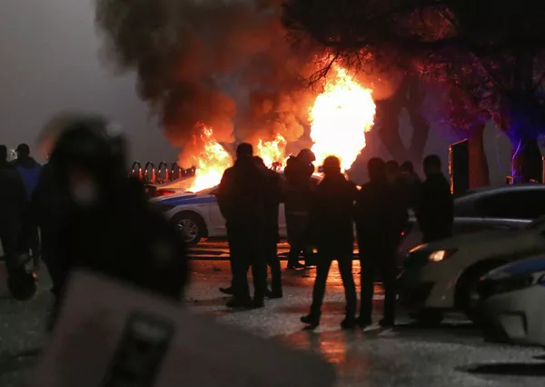 Varias compañías aéreas ya han anunciado retrasos o cancelaciones de vuelos con destino a Kazajistán mientras que el aeropuerto de Almaty había sido tomado por los manifestantes.En la foto: varias personas alrededor de un coche policía en llamas. Varias compañías aéreas ya han anunciado retrasos o cancelaciones de vuelos con destino a Kazajistán mientras que el aeropuerto de Almaty había sido tomado por los manifestantes.En la foto: varias personas alrededor de un coche policía en llamas. - Sputnik Mundo