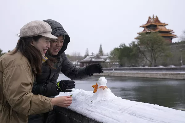Una pareja construye un muñeco de nieve cerca de la Ciudad Prohibida en Pekín, China, el 7 de noviembre de 2021. Una pareja construye un muñeco de nieve cerca de la Ciudad Prohibida en Pekín, China, el 7 de noviembre de 2021. - Sputnik Mundo