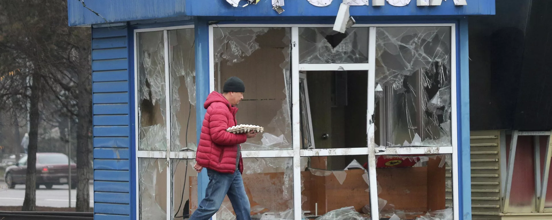 Un hombre pasa frente a una estación de Policía, destrozada durante las protestas masivas provocadas por el aumento del precio del combustible, en Almaty, Kazajistán, el 8 de enero de 2022 Un hombre pasa frente a una estación de Policía, destrozada durante las protestas masivas provocadas por el aumento del precio del combustible, en Almaty, Kazajistán, el 8 de enero de 2022 - Sputnik Mundo, 1920, 08.01.2022