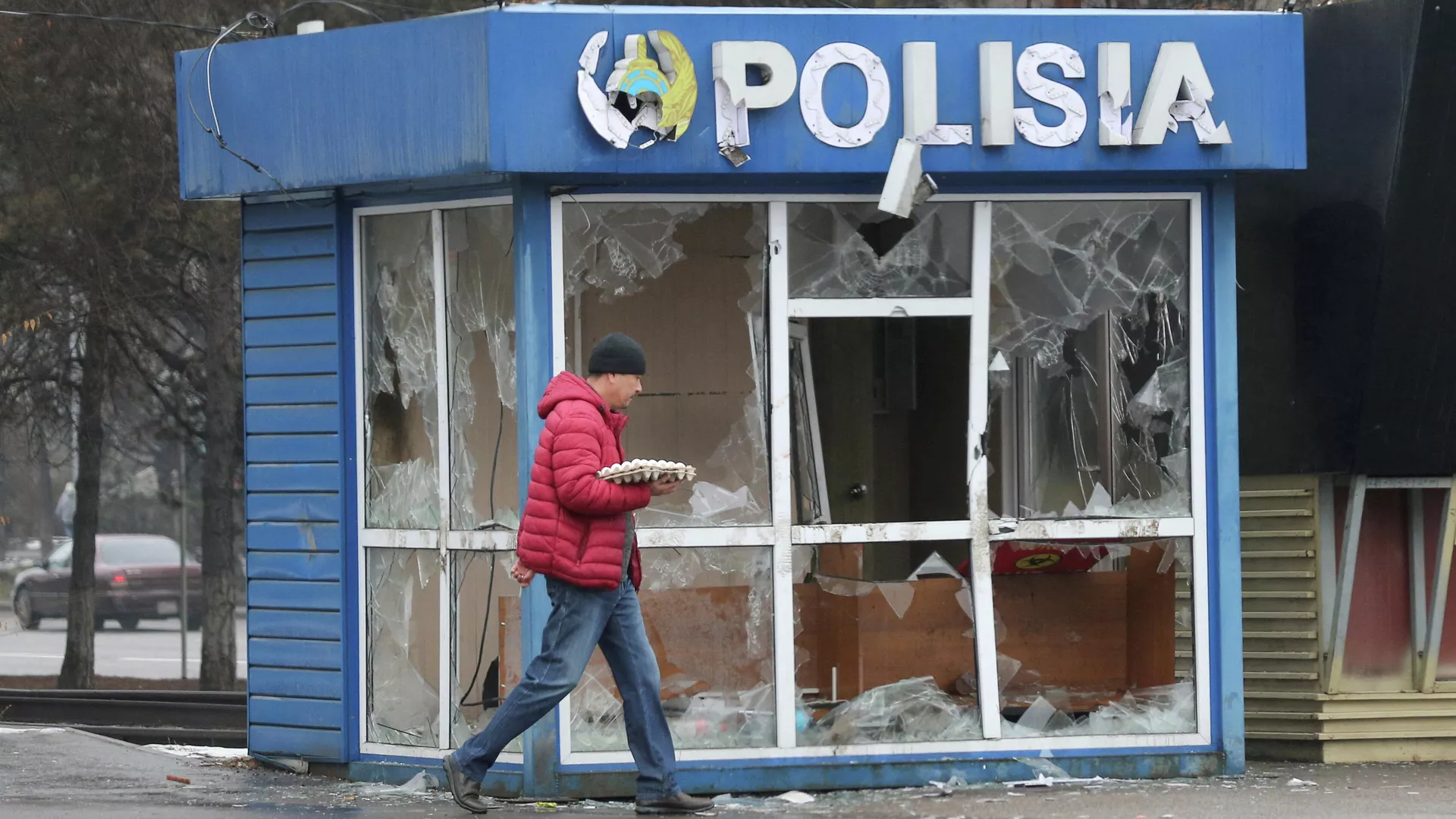 Un hombre pasa frente a una estación de Policía, destrozada durante las protestas masivas provocadas por el aumento del precio del combustible, en Almaty, Kazajistán, el 8 de enero de 2022