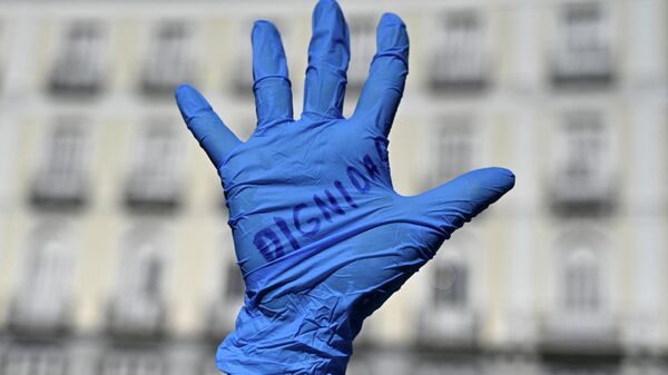 La palabra dignidad escrita en el guante de un trabajador sanitario. Protesta en la Puerta del Sol, Madrid, 12 de octubre de 2020 - Sputnik Mundo