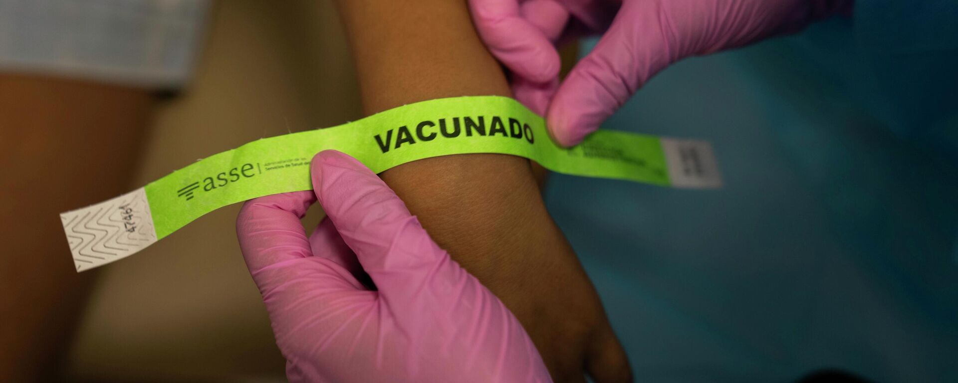 Una enfermera asegura un brazalete que dice vacunado - Sputnik Mundo, 1920, 12.01.2022