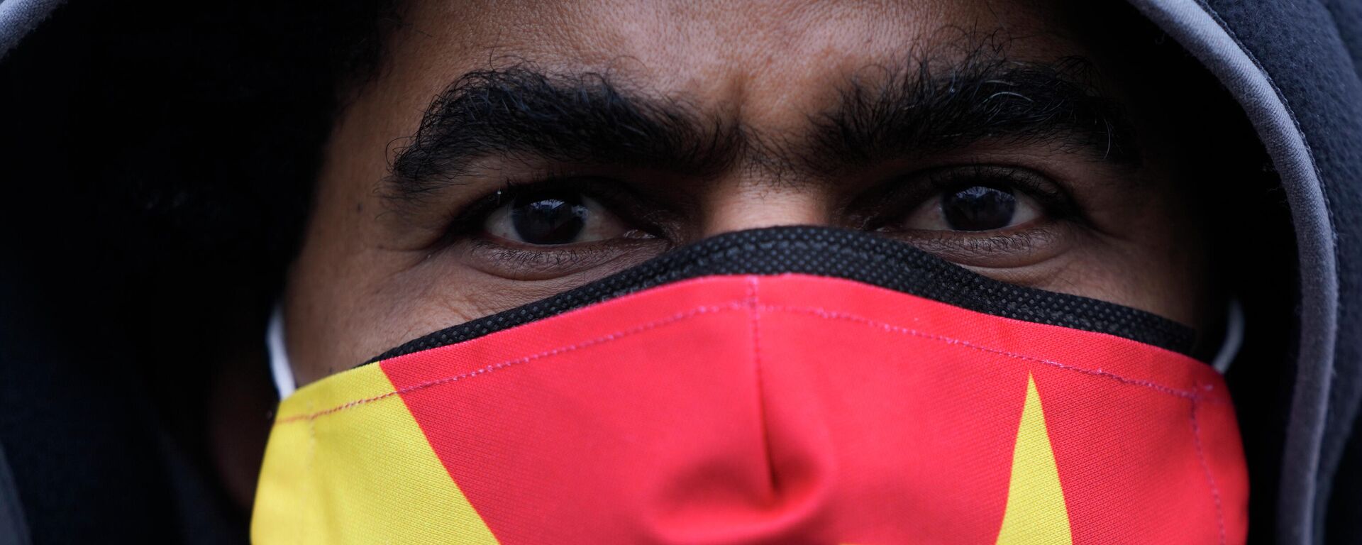 Un manifestante lleva una máscara con los colores de la bandera regional de Tigray mientras asiste a una protesta en Berlín, Alemania - Sputnik Mundo, 1920, 14.01.2022