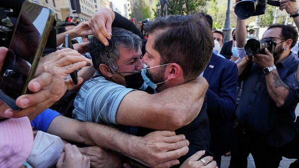 El presidente electo de Chile, Gabriel Boric, se abraza con simpatizantes - Sputnik Mundo