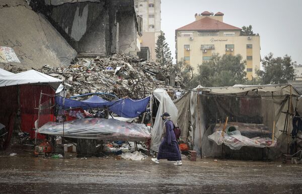 En medio de las difíciles condiciones climáticas en Gaza, han ocurrido al menos ocho accidentes automovilísticos graves. Nueve casas han sido afectadas por los incendios provocados por el uso de calentadores en climas fríos. En la foto: una mujer en una calle de la ciudad de Gaza. - Sputnik Mundo