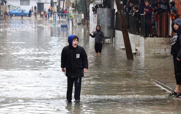 La Franja de Gaza es un territorio en la costa mediterránea de 40 km de largo y entre 4 y 6 km de ancho, una de las dos partes del Estado árabe de Palestina parcialmente reconocido junto con el territorio de la ribera occidental del río Jordán. Por el este y el norte, el sector limita con Israel, del que está separado por una valla divisoria con puestos de control.En la foto: varios niños en una calle inundada en la ciudad de Gaza. - Sputnik Mundo