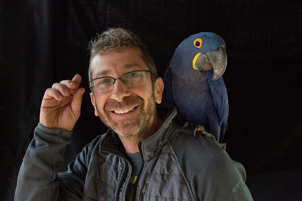 David Grunbaum fotografiado con un guacamayo - Sputnik Mundo