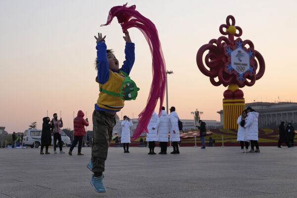 Un niño juega con un pañuelo rojo en la plaza de Tiananmen en Pekín, China. - Sputnik Mundo