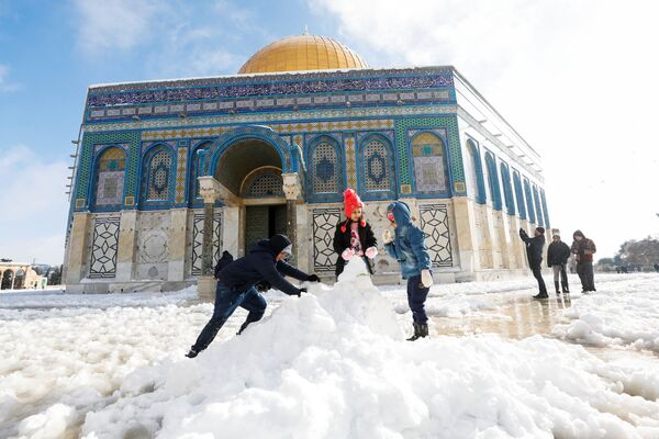 Una fuerte nevada ha caído en Israel. Jerusalén amaneció el 27 de enero con unos entre 10 y 25 cm de nieve. Los Altos del Golán también han quedado cubiertos. Una capa de nieve de un metro de espesor se formó en el Monte Hermón. Las clases en las escuelas de Jerusalén se cancelaron y se registraron horas de atascos en las carreteras debido al fenómeno. En la foto: Tres niños hacen un muñeco de nieve frente a la mezquita Cúpula de la Roca, también conocida como Domo de la Roca, en la Ciudad Vieja de Jerusalén. - Sputnik Mundo