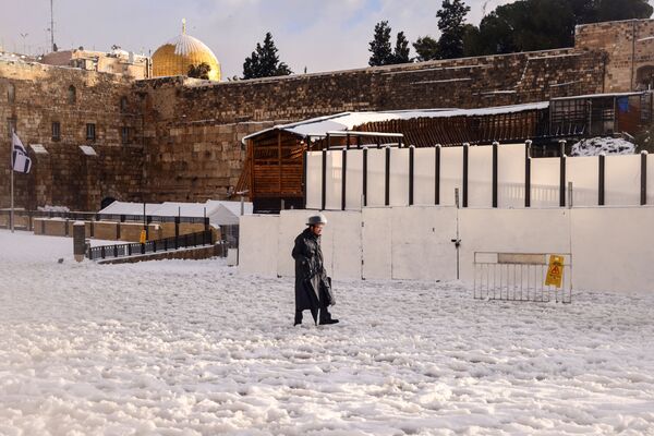 La lluvia hizo que se formara una densa niebla en las zonas bajas, lo que volvió a dificultar la conducción por la autopista en Jerusalén. En la foto: un judío ortodoxo camina cerca del Muro de las Lamentaciones en Jerusalén. - Sputnik Mundo