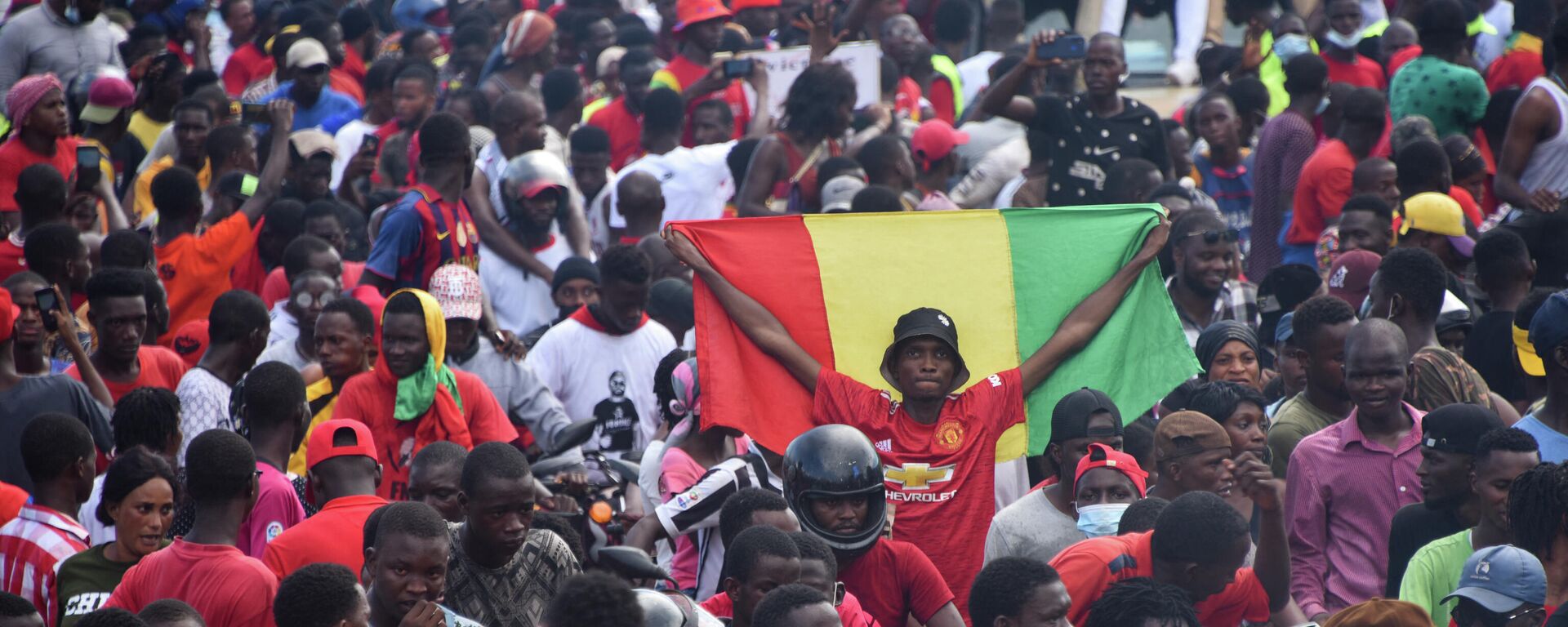 Un partidario sostiene una bandera nacional guineana mientras los activistas exiliados llegan a Conakry (archivo) - Sputnik Mundo, 1920, 03.02.2022