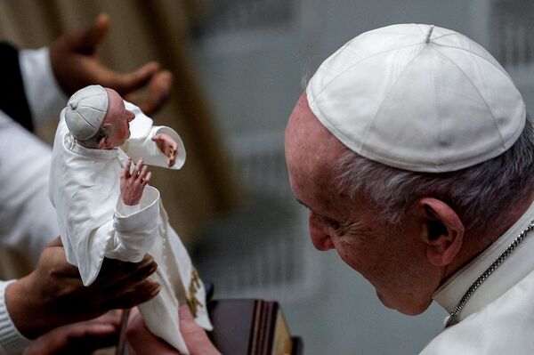 El papa Francisco observa su escultura en miniatura en manos de un feligrés durante su audiencia general semanal en el Vaticano. El papa Francisco observa su escultura en miniatura en manos de un feligrés durante su audiencia general semanal en el Vaticano. - Sputnik Mundo
