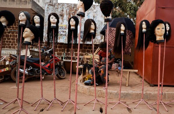 Un vendedor ambulante de pelucas en la ciudad de Uagadugú (Burkina Faso). Un vendedor ambulante de pelucas en la ciudad de Uagadugú (Burkina Faso). - Sputnik Mundo