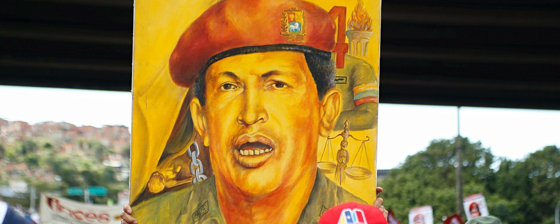 Chavista carga un cuadro de Hugo Chávez en Caracas  - Sputnik Mundo, 1920, 04.03.2022