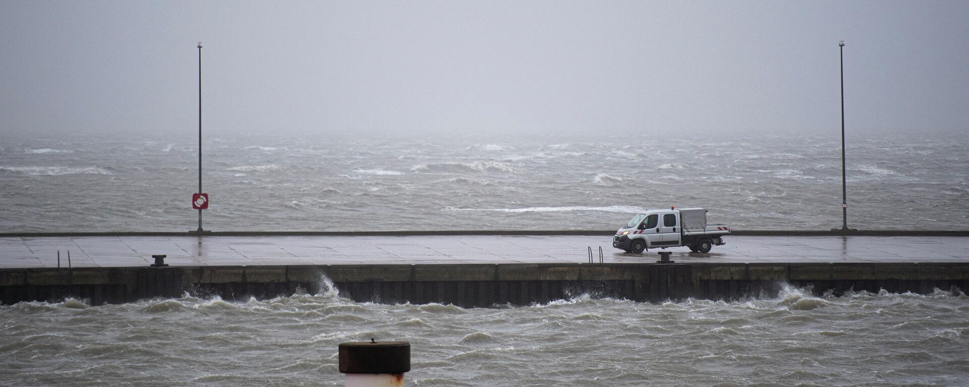 Un vehículo del municipio de Buesum en el muelle del puerto de Buesum, en el norte de Alemania, a principios del 17 de febrero de 2022, tras una fuerte tormenta que azotó Alemania  - Sputnik Mundo, 1920, 17.02.2022