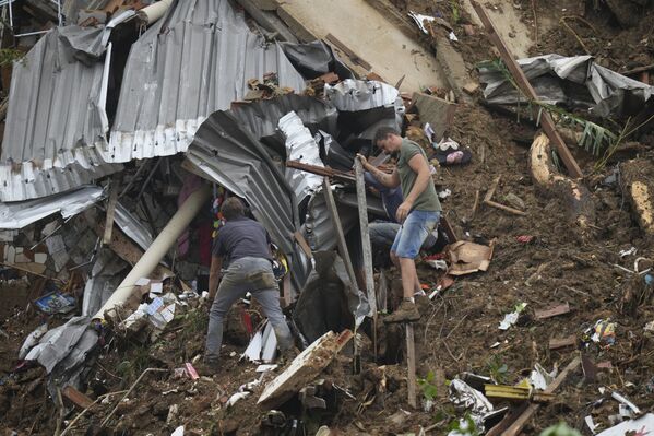 Unas 104 personas murieron a causa de las fuertes lluvias y los deslizamientos de tierra en la ciudad de Petrópolis, en el estado brasileño de Río de Janeiro. Se sabe que al menos ocho de ellos son menores de edad.En la foto: los residentes de la ciudad están buscando personas bajo los escombros. - Sputnik Mundo