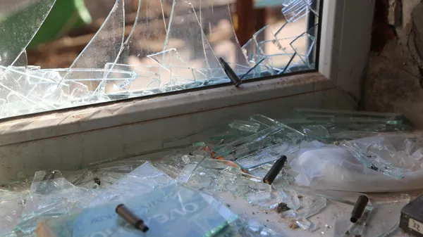 Una ventana rota y proyectiles en el alféizar de una ventana de un edificio de apartamentos en el distrito Kievski de Donetsk - Sputnik Mundo