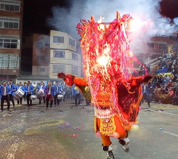 Los trajes de la Diablada llegan a pesar 20 kilos, que los danzarines cargan con la mayor gracia posible durante horas de recorrido. Para demostrar su fe en la Virgen del Socavón algunos no dudaron en cubrirse de chispas y también algo de fuego. - Sputnik Mundo