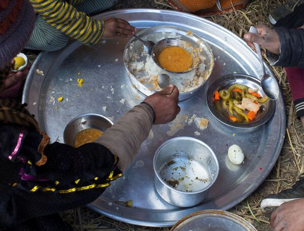 La tribu El Dawagra está compuesta por más de 300 familias de pastores que recorren la tierra como nómadas desde hace varias generaciones. En la foto: El almuerzo de una familia en un campamento beduino. - Sputnik Mundo