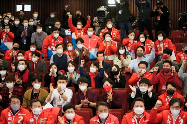 La participación en las elecciones fue del 77,1%. Unos 34 millones de los 44 millones de votantes emitieron su voto.En la foto: varios miembros del Partido del Poder Popular en Seúl siguen los informes sobre los resultados de las elecciones presidenciales. - Sputnik Mundo