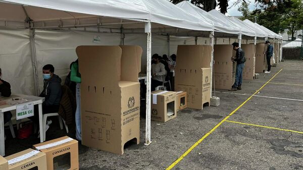 En cada mesa de votación hay tres cajas para depositar los votos y un atril de cartón en el que las personas ejercen su derecho democrático. - Sputnik Mundo