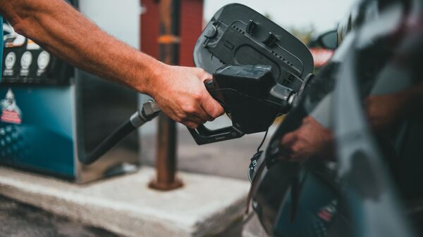 Una persona cargando combustible en su automóvil (imagen referencial) - Sputnik Mundo