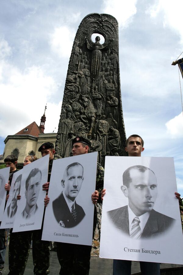 Año 2009. Varios jóvenes se reúnen en el centro de la ciudad de Leópolis cerca del monumento de Stepán Bandera, un colaborador nazi cuyas tropas participaron en el Holocausto, durante la celebración del Día de los Héroes por los veteranos del Ejército Insurgente Ucraniano. Los participantes llevan los retratos de los miembros de la Organización de nacionalistas ucranianos. - Sputnik Mundo