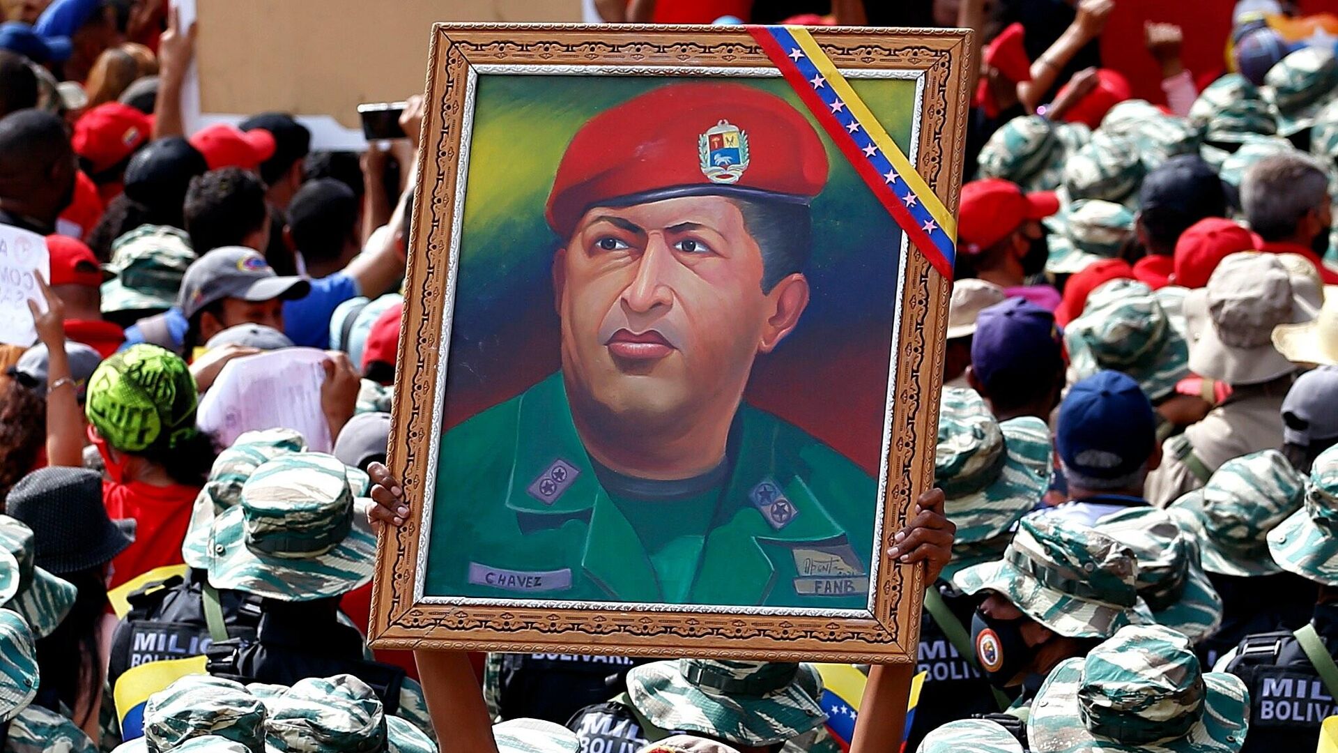 Miliciana porta un cuadro con la imagen de Hugo Chávez durante el Día de la Milicia Nacional Bolivariana Miliciana porta un cuadro con la imagen de Hugo Chávez durante el Día de la Milicia Nacional Bolivariana - Sputnik Mundo, 1920, 14.04.2022