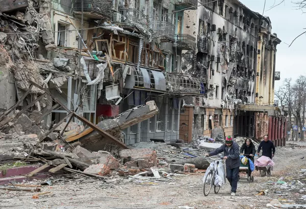 Los habitantes de la ciudad ucraniana de Mariúpol caminan por una calle al lado de los edificios destruidos. Los habitantes de la ciudad ucraniana de Mariúpol caminan por una calle al lado de los edificios destruidos. - Sputnik Mundo