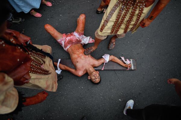 Los devotos venezolanos recrean la crucifixión de Jesús durante una procesión de Viernes Santo en el barrio Petare, en Caracas. - Sputnik Mundo