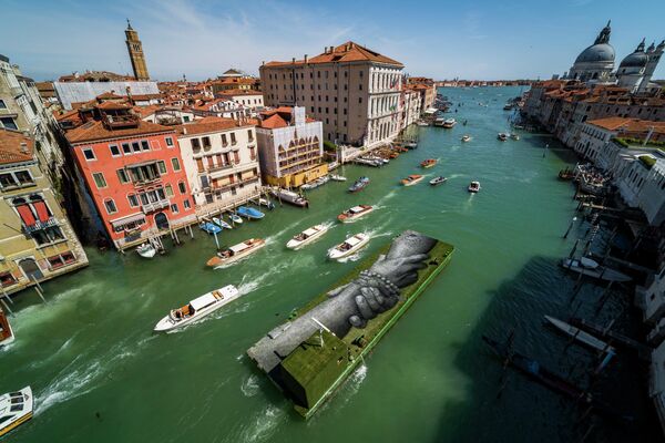 Una enorme pintura biodegradable del artista franco-suizo Guillaume Legros, más conocido como Saype, en una barcaza flotante en Venecia, Italia. Esta pintura tiene una superficie de ocho por 30 metros y ha sido creada con pigmentos biodegradables hechos de carbón, tiza, agua y proteínas de leche. La obra se presentará durante la 59ª Bienal de Arte de Venecia. - Sputnik Mundo