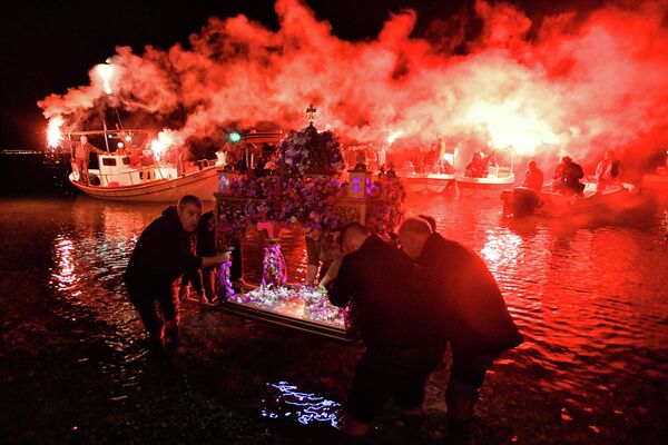 Un grupo de cristianos ortodoxos participa en la procesión del epitafio del Viernes Santo en la playa de Loutraki, Grecia, el 22 de abril de 2022. - Sputnik Mundo