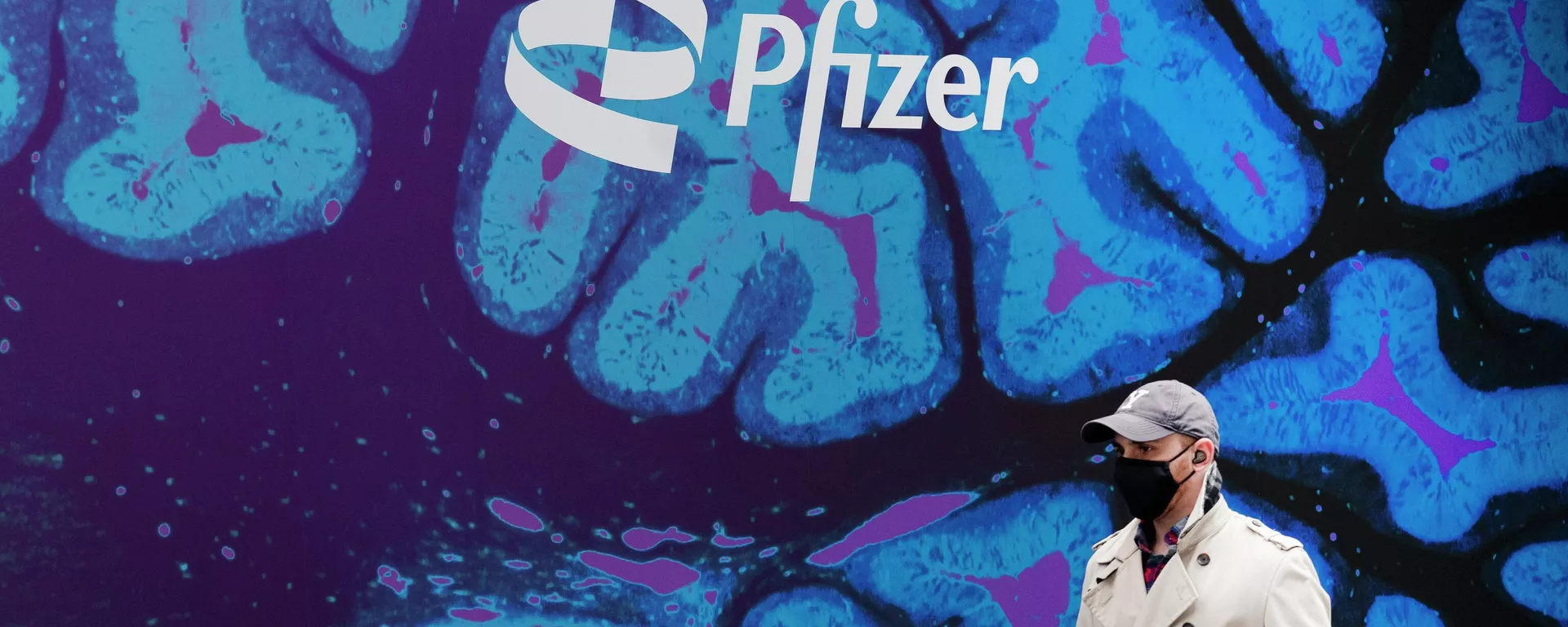 Un hombre pasa por la sede de Pfizer - Sputnik Mundo, 1920, 11.05.2022