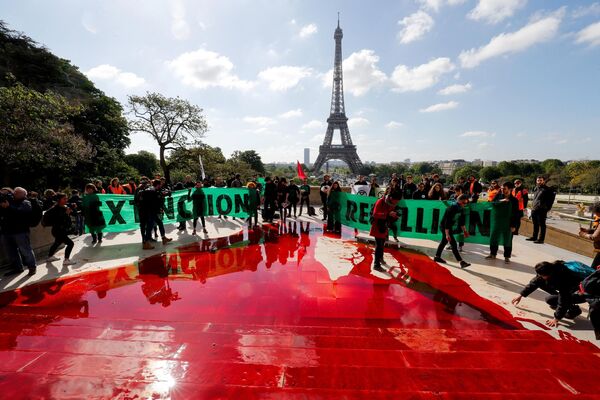 El movimiento social y político Extinction Rebellion en su lucha contra el cambio climático y disminución de la biodiversidad utiliza el accionismo que difumina la línea entre el arte y la realidad.En la foto: activistas de Extinction Rebellion durante una acción frente a la Torre Eiffel en París (Francia) protestan contra el rápido declive de la biodiversidad, 12 de mayo de 2019. - Sputnik Mundo