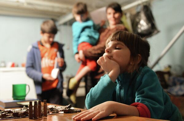 Esta niña de Donetsk vivía en el sótano del Hospital 21 con sus padres porque en noviembre de 2014 su casa fue destruida por el Ejército ucraniano. En esta foto, ella juega con los proyectiles de un fusil. Este tipo de &#x27;juguetes&#x27; se han convertido en habituales para los niños que crecieron bajo los bombardeos. - Sputnik Mundo