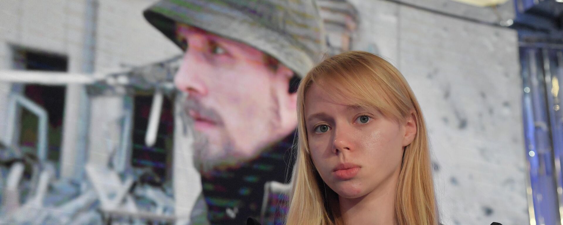 Ekaterina Prokopenko, esposa del líder del batallón neonazi Azov, Denis Prokopenko, con la foto de su marido en el fondo - Sputnik Mundo, 1920, 25.05.2022