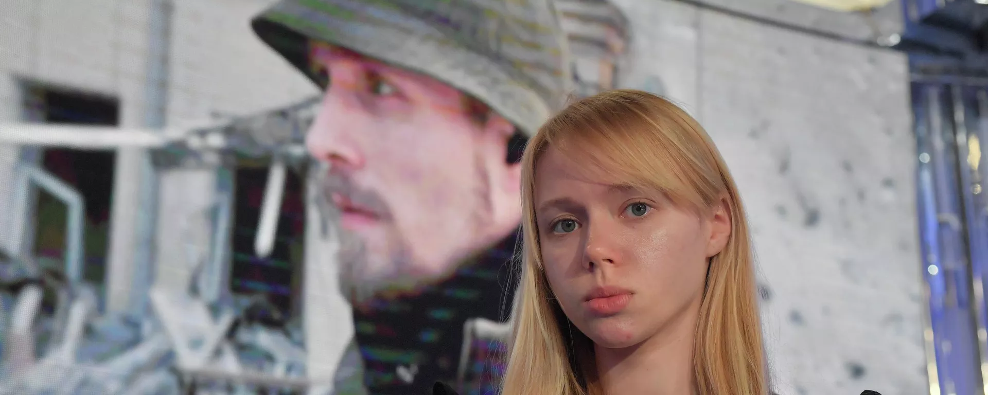 Ekaterina Prokopenko, esposa del líder del batallón neonazi Azov, Denis Prokopenko, con la foto de su marido en el fondo - Sputnik Mundo, 1920, 25.05.2022