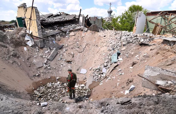 Un militar de la República Popular de Lugansk se para sobre un socavón que resultó de un ataque aéreo de las Fuerzas Armadas de Ucrania en el pueblo de Yatskovka, en el territorio del distrito Liman de la República Popular de Donetsk. Un militar de la República Popular de Lugansk se para sobre un socavón que resultó de un ataque aéreo de las Fuerzas Armadas de Ucrania en el pueblo de Yatskovka, en el territorio del distrito Liman de la República Popular de Donetsk. - Sputnik Mundo