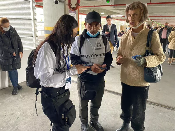 Una ciudadana se acerca a los infovotantes de la Registraduría, personas que estuvieron en todos los puestos de la ciudad para ayudar a las personas a encontrar su mesa. Una ciudadana se acerca a los infovotantes de la Registraduría, personas que estuvieron en todos los puestos de la ciudad para ayudar a las personas a encontrar su mesa. - Sputnik Mundo