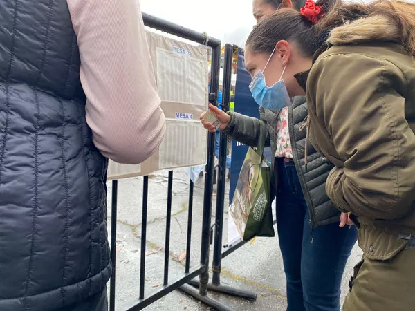 Una mujer, en el centro de la ciudad, mira el listado para encontrar su número de documento y saber cuál es su mesa de votación. Una mujer, en el centro de la ciudad, mira el listado para encontrar su número de documento y saber cuál es su mesa de votación. - Sputnik Mundo