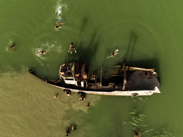 Unos niños se bañan cerca de un barco abandonado en el río Shatt al-Arab, en Irak. Unos niños se bañan cerca de un barco abandonado en el río Shatt al-Arab, en Irak. - Sputnik Mundo