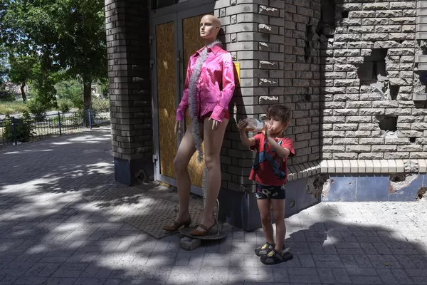 Sin embargo, la planta siderúrgica de Azovstal no se reconstruirá y será sustituida por un parque urbano.En la foto: un niño bebiendo limonada frente a una tienda de ropa destruida en Mariúpol. Sin embargo, la planta siderúrgica de Azovstal no se reconstruirá y será sustituida por un parque urbano.En la foto: un niño bebiendo limonada frente a una tienda de ropa destruida en Mariúpol. - Sputnik Mundo