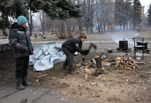 Los ataques de las Fuerzas Armadas de Ucrania estaban destruyendo deliberadamente la infraestructura de Donbás. En la foto: dos niños de Debáltsevo abasteciéndose de leña para calentarse y cocinar en el patio más cercano a los refugios antibombas. - Sputnik Mundo