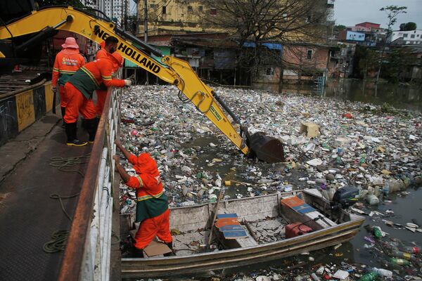 Unos trabajadores municipales sacan la basura del río Negro, en el estado brasileño de Amazonas, tras una inundación. - Sputnik Mundo