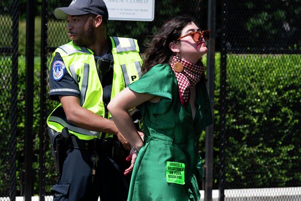 Una multitud de manifestantes destrozaba todo a su paso, tratando de romper los cordones policiales.En la foto: la Policía detiene a una manifestante que derramó pintura roja en la acera frente al Tribunal Supremo en Washington. Una multitud de manifestantes destrozaba todo a su paso, tratando de romper los cordones policiales.En la foto: la Policía detiene a una manifestante que derramó pintura roja en la acera frente al Tribunal Supremo en Washington. - Sputnik Mundo