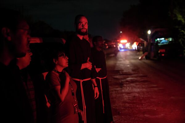 Las mujeres, los hombres y los adolescentes que viajaban en el remolque podrían haber muerto de un golpe de calor, ya que la temperatura en el lugar de la tragedia se acercaba a los 40 grados centígrados y era aún mayor en el camión recalentado.En la foto: sacerdotes de la Diócesis de San Antonio en el camión en el que se encontraron los cuerpos de los migrantes muertos. - Sputnik Mundo