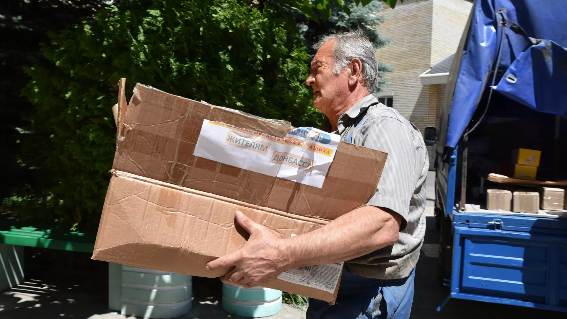 Un hombre con una caja de ayuda humanitaria para Donbás - Sputnik Mundo, 1920, 07.07.2022