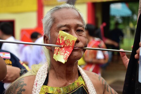 El desfile en honor a la diosa del templo Gow Lengchi no es el único de este tipo. Cada otoño, en la isla de Phuket, la comunidad china en Tailandia celebra un Festival Vegetariano extremo, también conocida como la Fiesta de los Nueve Dioses Emperadores, donde los participantes se perforan las mejillas, la lengua y otras partes del cuerpo con diversos objetos domésticos afilados. En la foto: Un participante con las mejillas perforadas durante el desfile en honor a la diosa del templo de Gow Lengchi en Narathiwat, al sur de Tailandia. - Sputnik Mundo